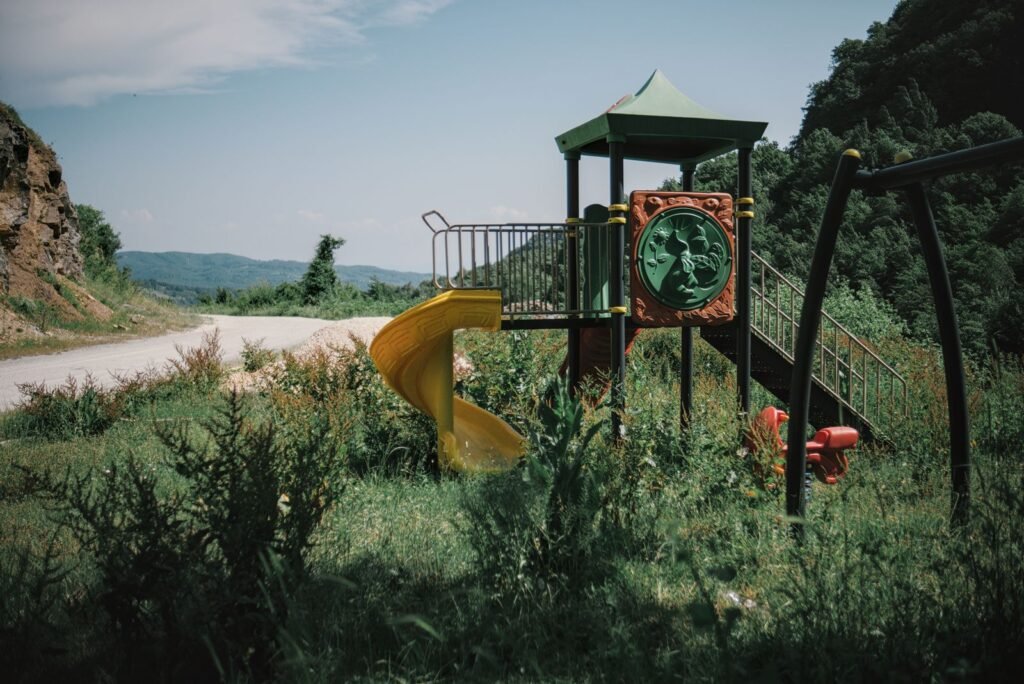 Empty playground in a rural countryside setting surrounded by fields and trees