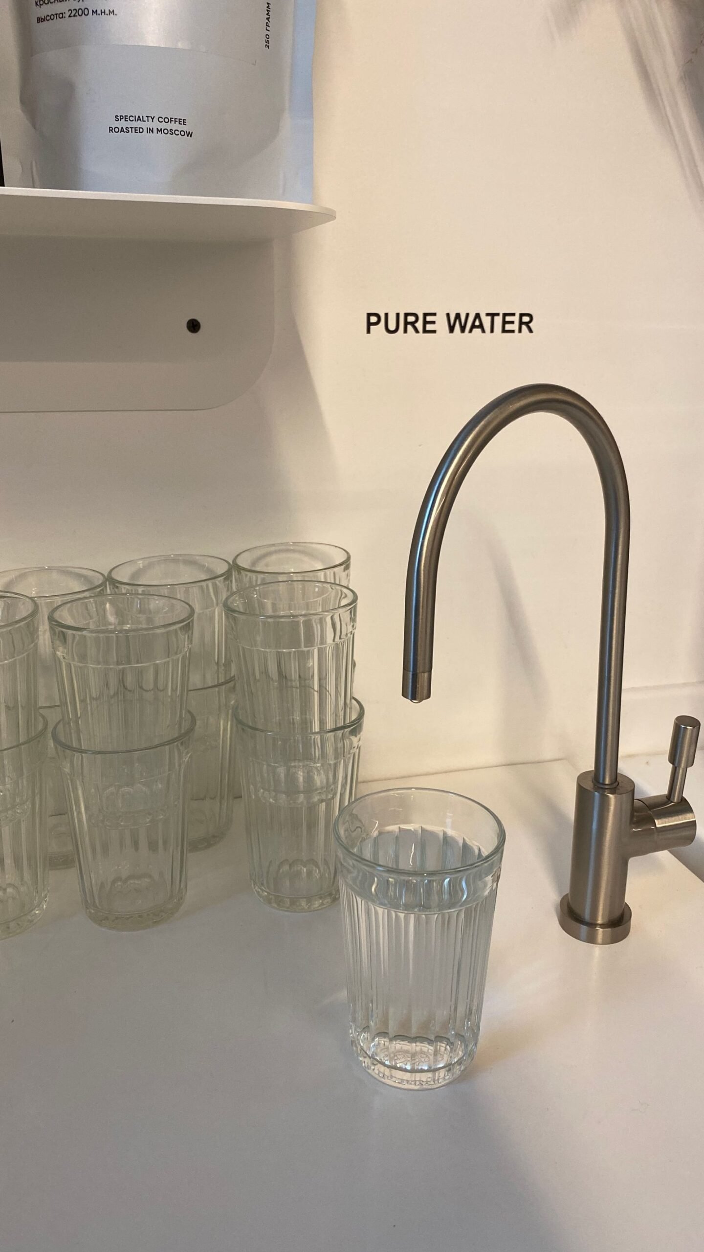 PFAS lawsuits: clean drinking glasses beside a kitchen faucet, representing PFAS in tap water