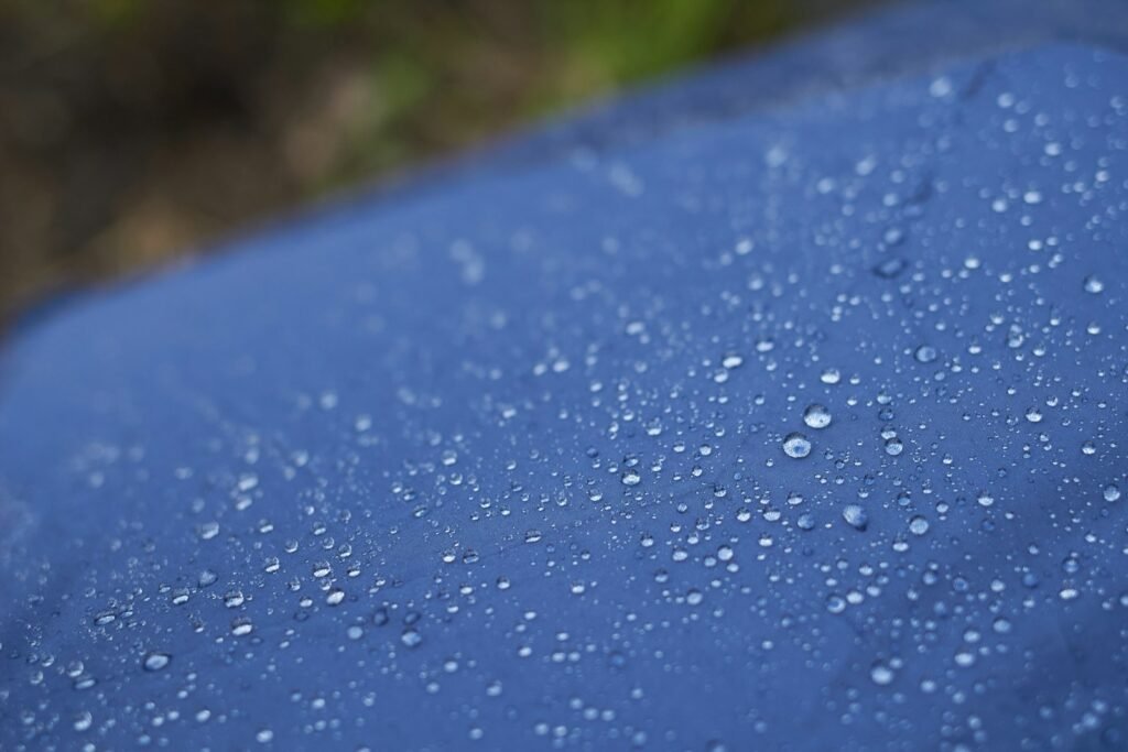 Water droplets beading on blue water-repellent fabric