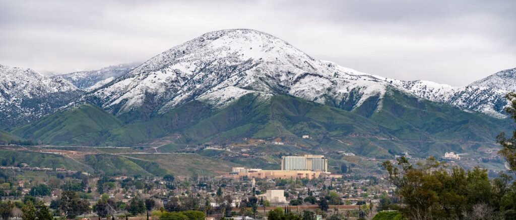 Polinsky Children's Center lawsuit: aerial winter view of snow-capped mountains above the San Bernardino cityscape