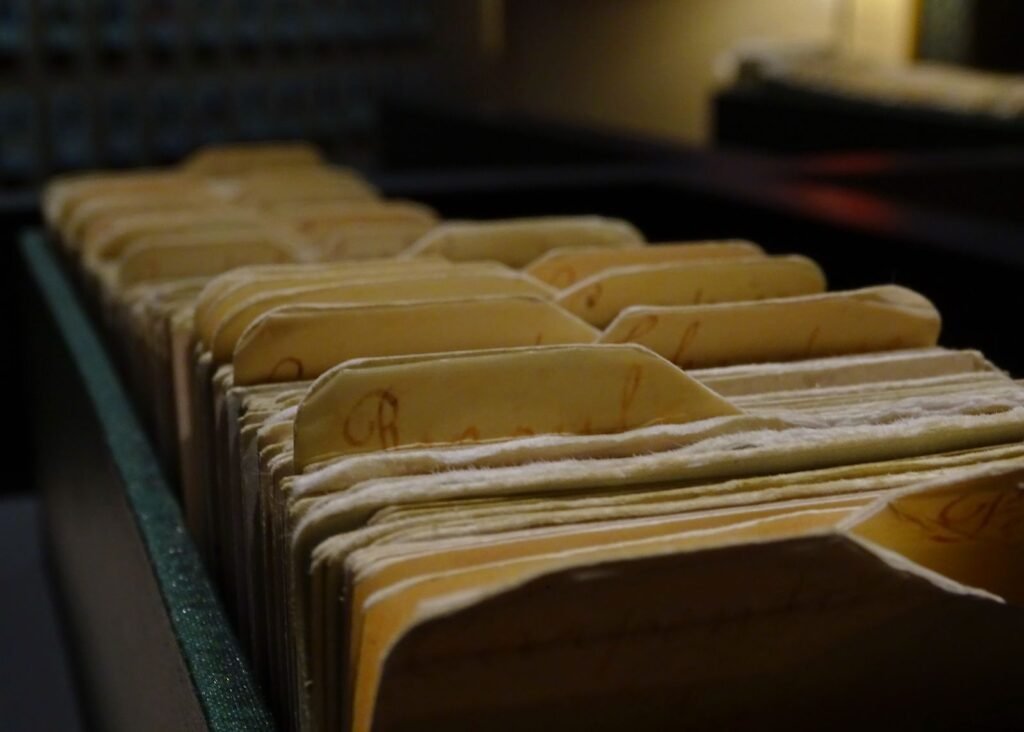 Rows of old file folders in a dim archive, representing juvenile and county records