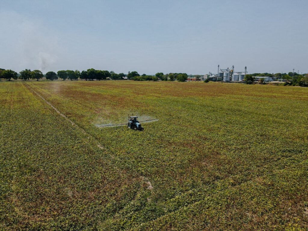 Aerial view of a tractor in a large farm field, the kind of site where chlorpyrifos exposure evidence begins