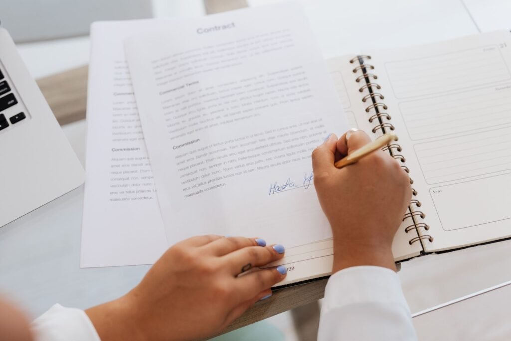 Hands signing an agreement at a desk, a step that comes only after a firm reviews Cartiva implant claims