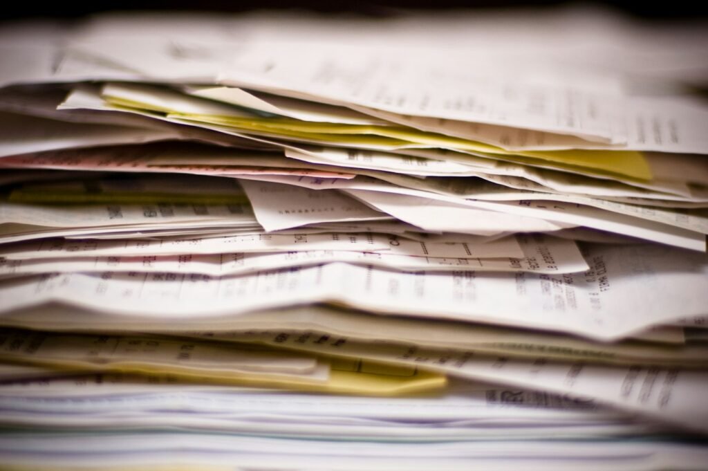 Tall stack of paperwork and receipts, the kind of records gathered to support a device injury claim