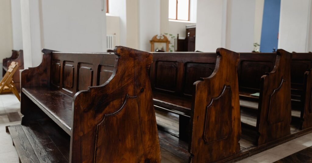 Empty wooden church pews, illustrating the Rhode Island clergy abuse attorney general report