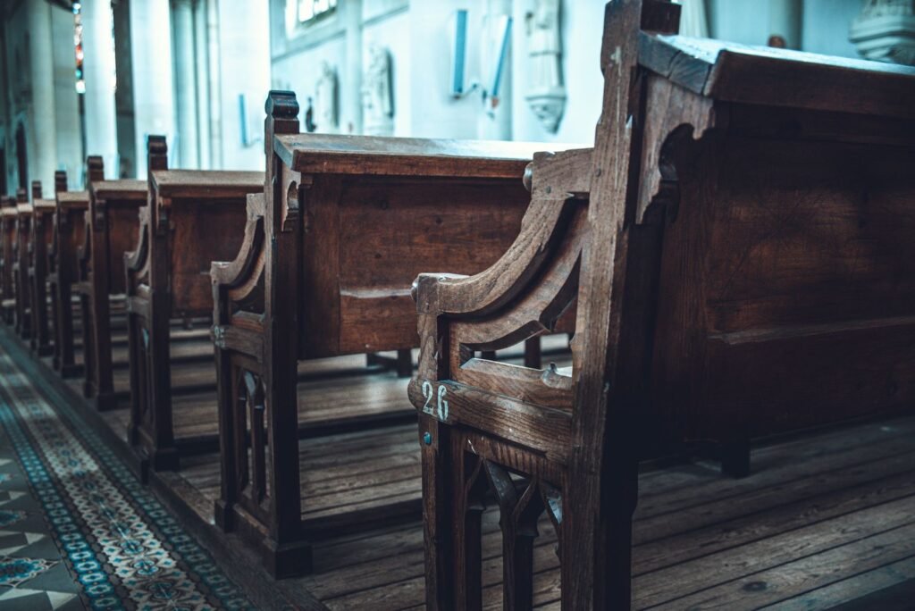 Rhode island revival window: rows of empty wooden church pews in a sunlit church