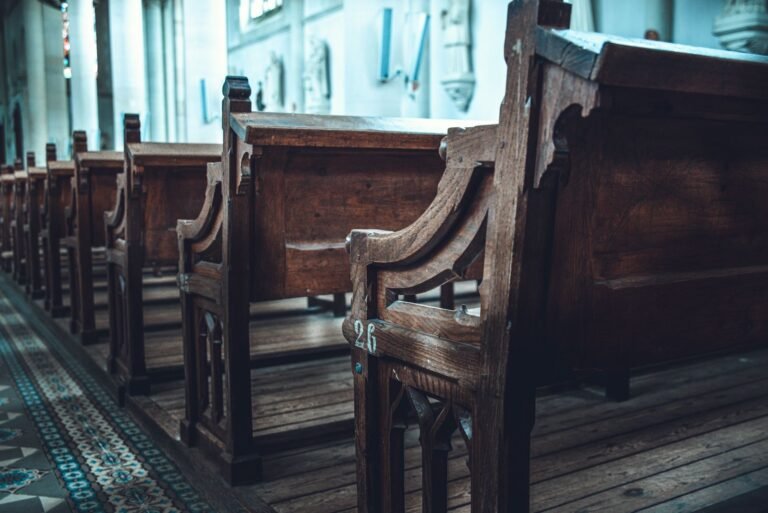 Rhode island revival window: rows of empty wooden church pews in a sunlit church