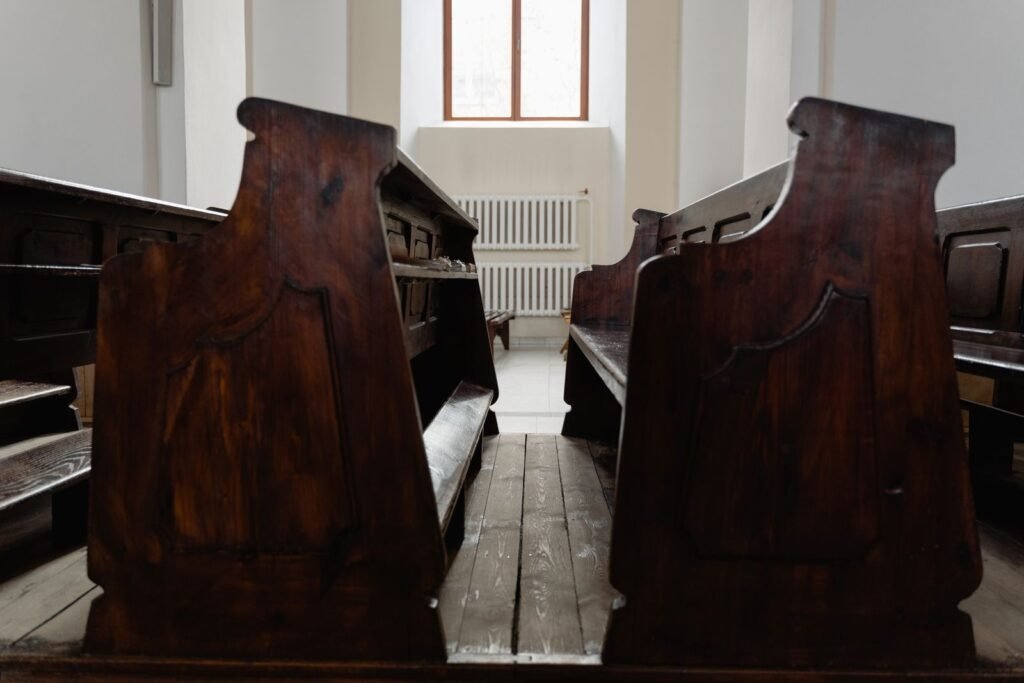 Rhode island revival window: empty wooden pews inside a church with light from a window