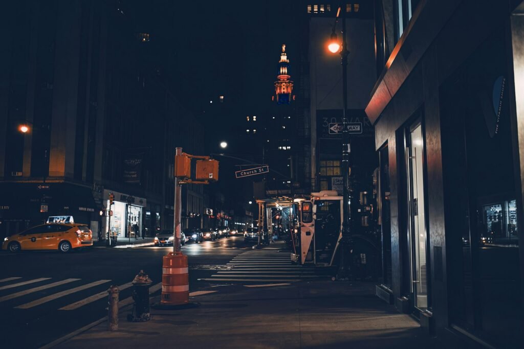 City street at night with a traffic light and passing cars