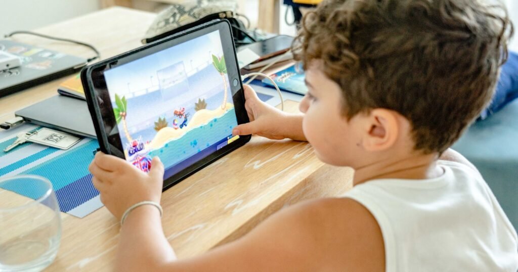 Young boy playing an online game on a tablet