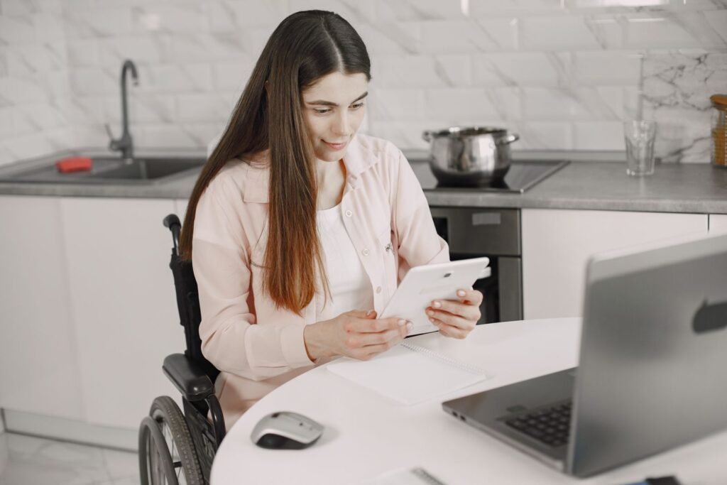 Woman in a wheelchair working on a tablet at her kitchen table, organizing an SSDI appeal