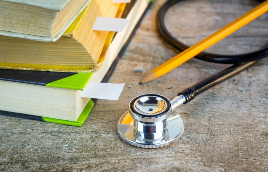 Medical textbooks with bookmarks and a stethoscope, symbolizing learning about Dupixent lymphoma treatment