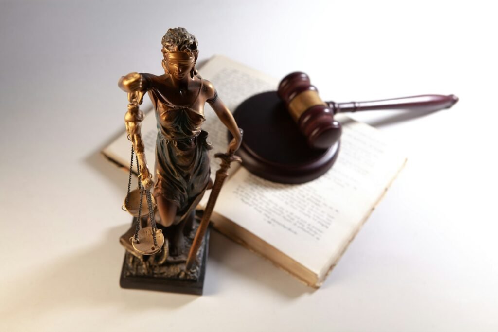 Statue of justice, gavel and open books on a table, representing family and state court cases