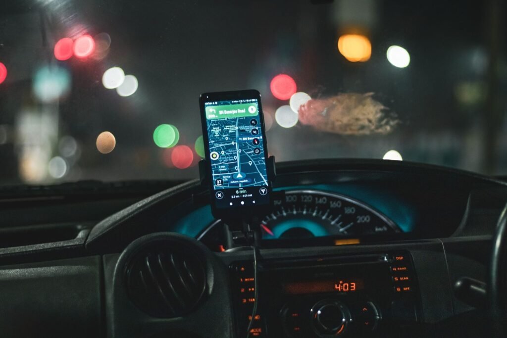 Smartphone map navigation in a car at night, part of the rideshare safety features riders can set up