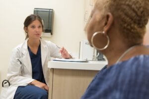 Doctor in consultation with a woman patient at a clinic, discussing transvaginal mesh complications