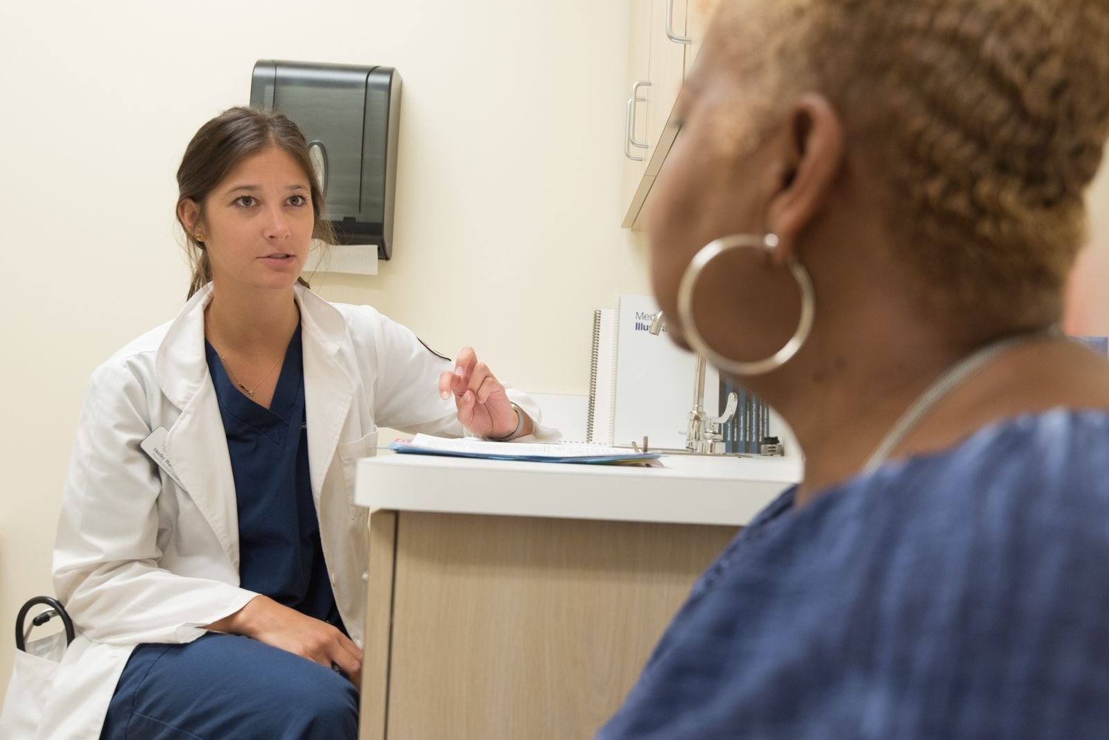 Doctor in consultation with a woman patient at a clinic, discussing transvaginal mesh complications