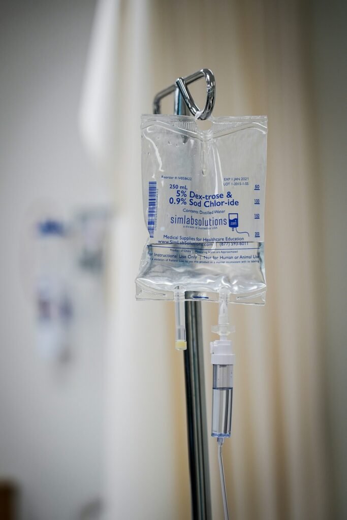 IV bag hanging from a metal pole in a hospital room during patient care