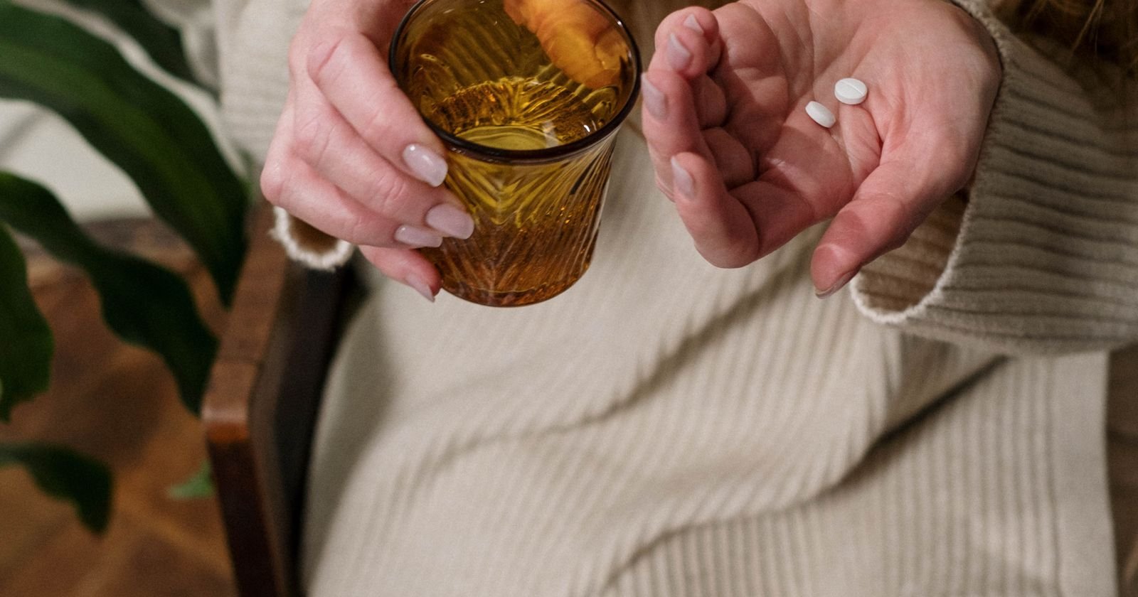 Woman holding a pill and glass of water, illustrating Tylenol autism lawsuit eligibility