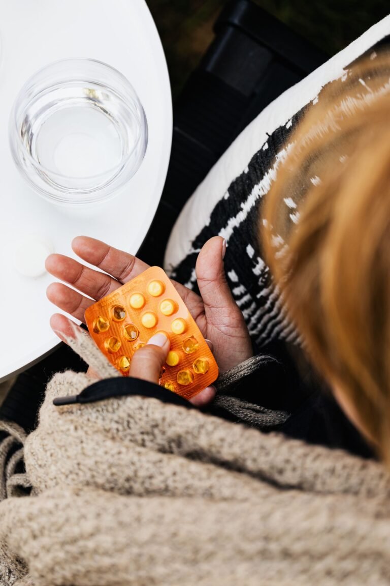 Tylenol autism lawsuit update: hands holding a blister pack of pain reliever pills beside a glass of water