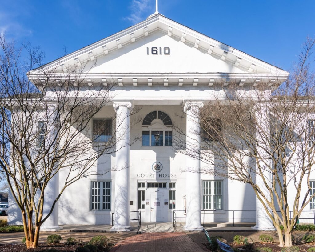 Front view of a historic neoclassical courthouse with columns under a clear sky