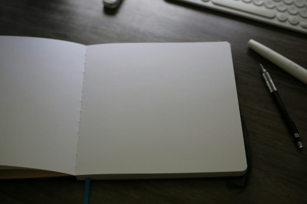 Open notebook beside a keyboard, used to log online exploitation evidence with dates and usernames