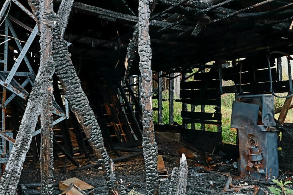 Interior of a burned building with charred wooden beams and debris after a fire